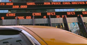 stock market ticker with taxi in foreground