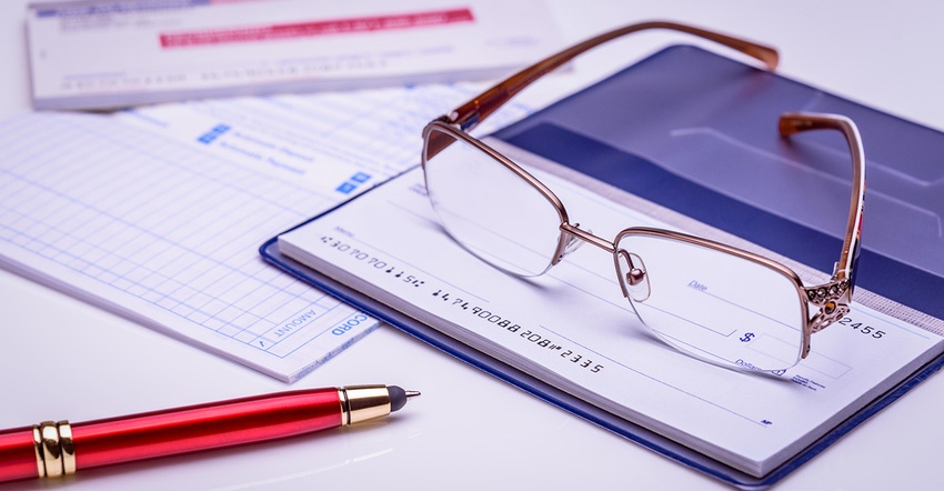 checkbook with pen and glasses