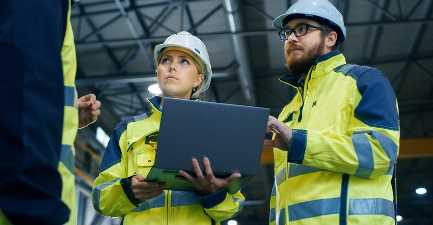 male and female factory workers with laptop