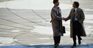 businessmen shaking hands on global background