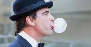 man in bowler hat blowing bubble