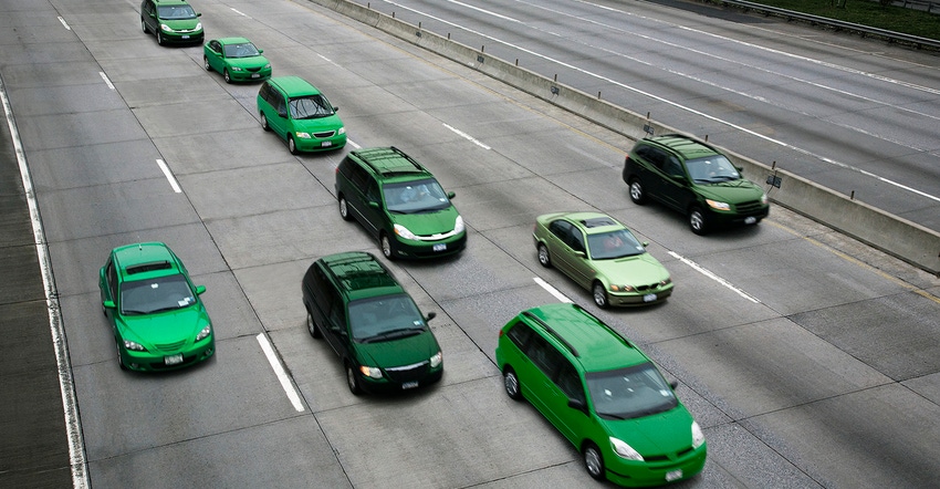 green cars driving in arrow formation