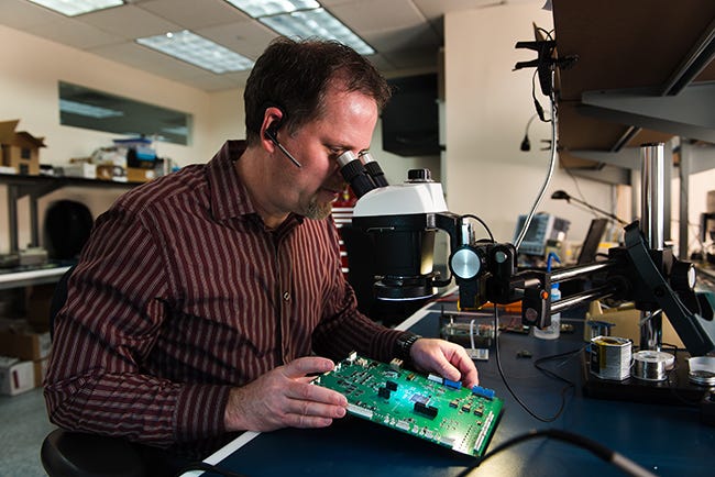man inspecting electronic part