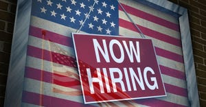 "Now hiring" sign hung across US flag