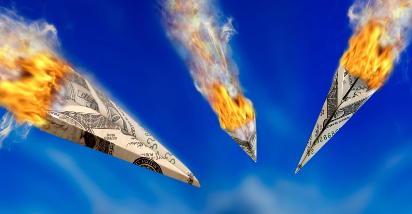 paper airplanes made of dollar bills on fire