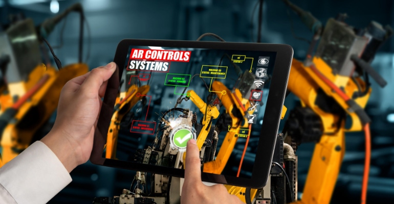 Engineer controls robotic arms by augmented reality manufacturing technology application software.