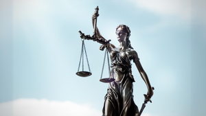 A statue of Lady Justice with a blue sky in the background. Credit: Canva A statue of Lady Justice with a blue sky in the background. Credit: Canva