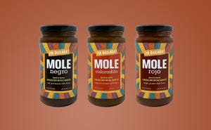 Three different flavors of ¡Ya Oaxaca!'s mole sauce are pictured on a sienna background.  Three different flavors of ¡Ya Oaxaca!'s mole sauce are pictured on a sienna background.
