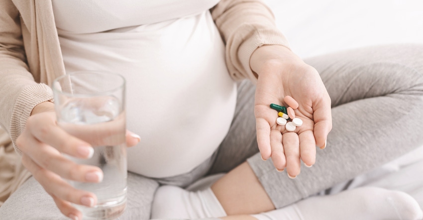 Pregnant woman taking vitamins Pregnant woman taking vitamins