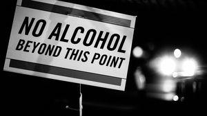 A black-and-white vintage sign announces "No alcohol beyond this point." A black-and-white vintage sign announces "No alcohol beyond this point."