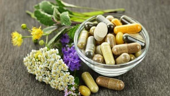 herbal supplements in a bowl and on a table