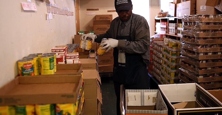 warehouse employee loads canned food into boxes