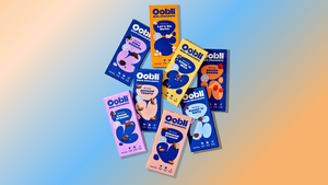 Oobli's selection of dark and milk chocolate bars that include the brand's sweet proteins in front of a gradient background of orange, white and blue. Oobli's selection of dark and milk chocolate bars that include the brand's sweet proteins in front of a gradient background of orange, white and blue.