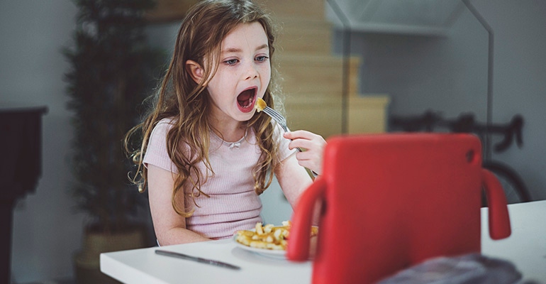 girl eating while watching an ipad