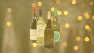 Four bottles of Whole Foods Market's private-label wines are featured in front of yellow party lights.  Four bottles of Whole Foods Market's private-label wines are featured in front of yellow party lights.
