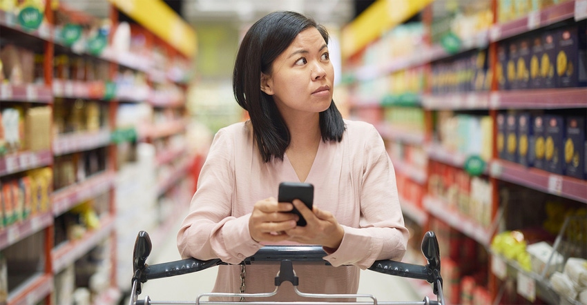 A woman shopping with a calculator looking concerned about grocery prices | Market Overview: Inflation complications persist A woman shopping with a calculator looking concerned about grocery prices | Market Overview: Inflation complications persist