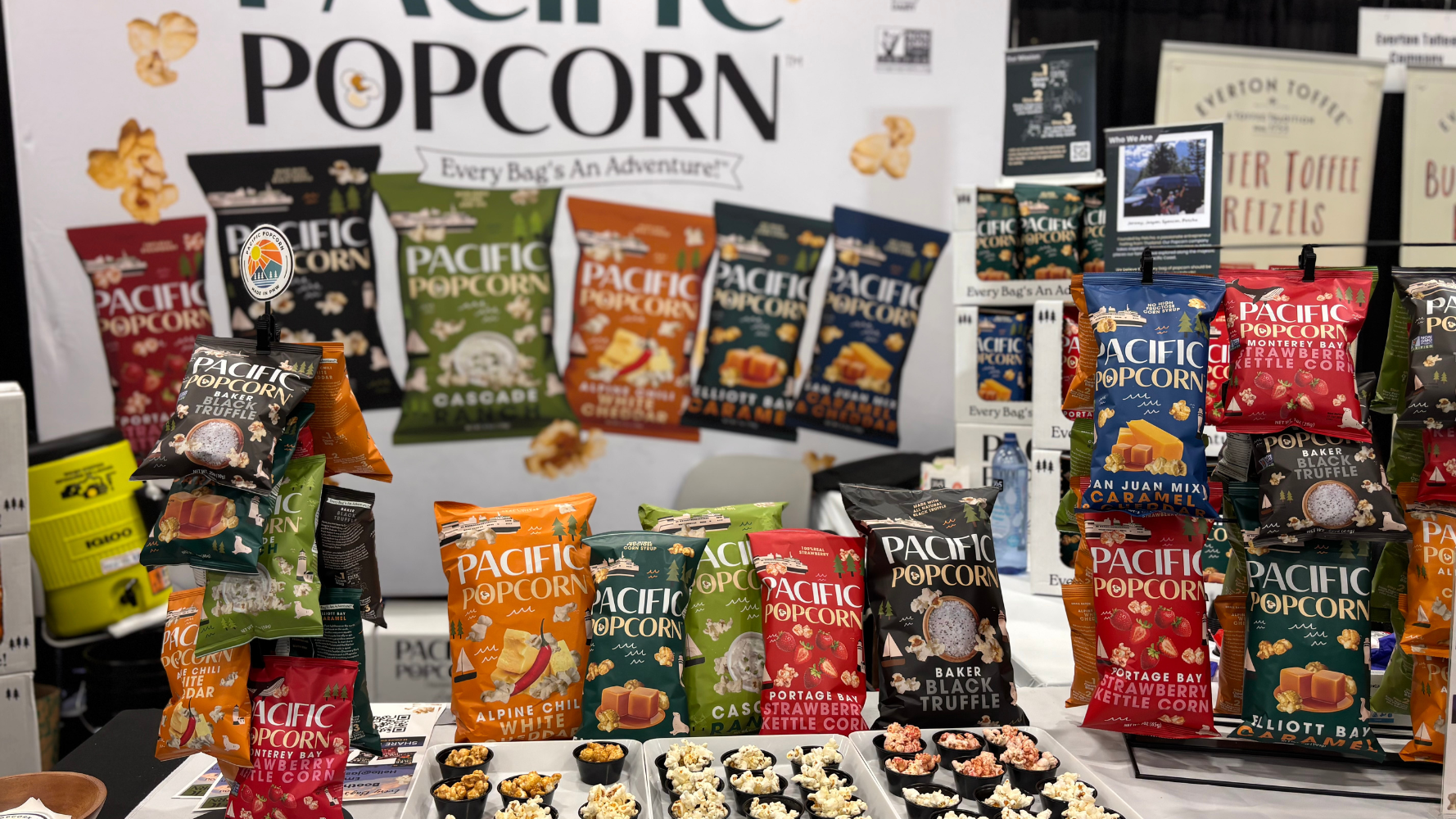 Pacific Popcorn displays its brightly colored packages and offers samples of its many flavors, which include Strawberry Kettle Corn, Cascade Ranch, White Cheddar, Blak Truffle and more.  Pacific Popcorn displays its brightly colored packages and offers samples of its many flavors, which include Strawberry Kettle Corn, Cascade Ranch, White Cheddar, Blak Truffle and more.