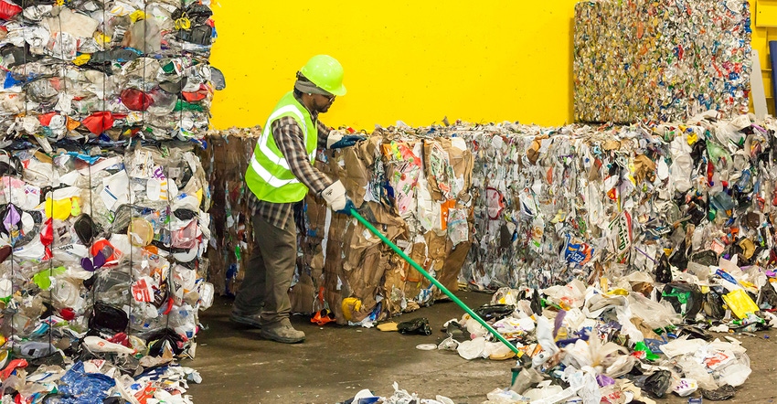 man sweeping up debris from bundled recycling waste | What to consider when creating sustainable packaging