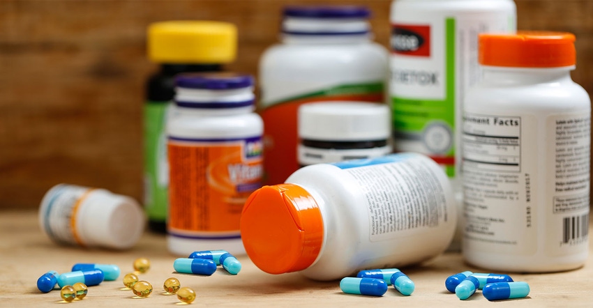 A collection of dietary supplement bottles with capsules and softgels A collection of dietary supplement bottles with capsules and softgels