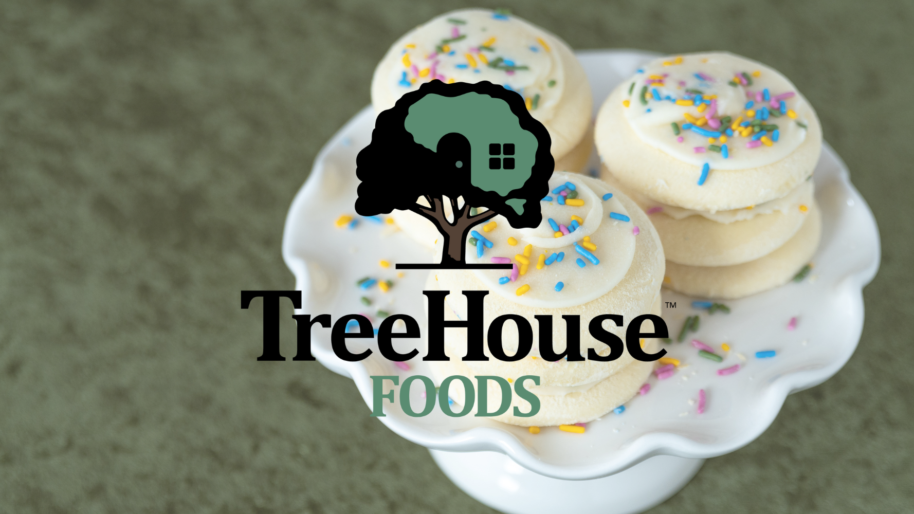 A tray of frosted cookies sits on a green countertop, with the TreeHouse Farms logo on top of the image.