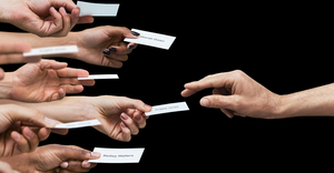 Hands holding papers with names