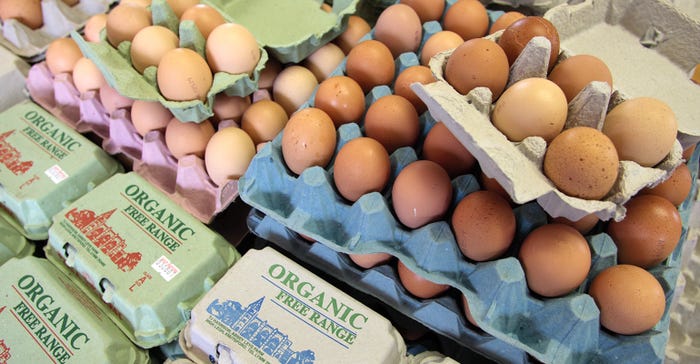 Free-range organic eggs; some are brown; several cartons are closed and labeled organic