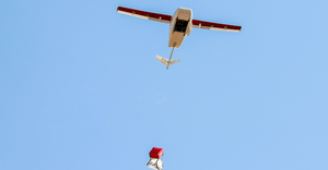 In this photograph, a Zipline drone is deliver blood preserves and medicals in parcel with parachute to rural clinics in