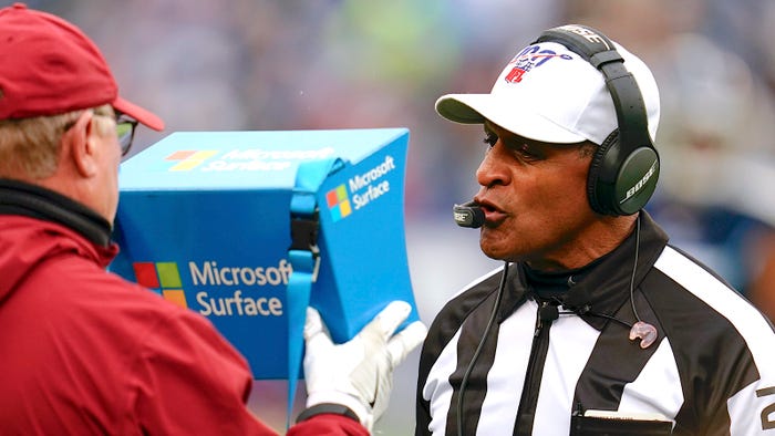  referee Jerome Boger #23 reviews instant replay on a Microsoft Surface tablet during an NFL football game