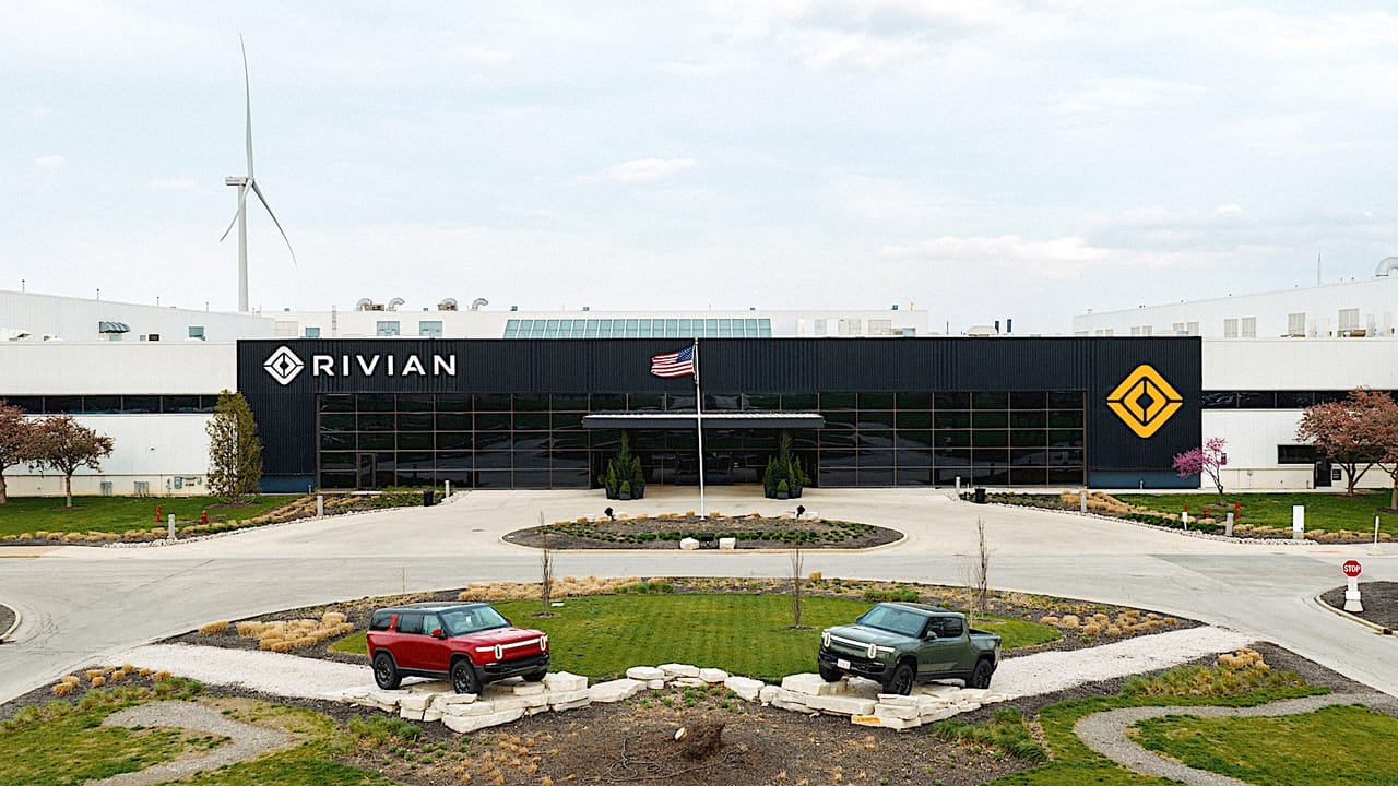 Rivian's plant in Normal, IL, with its wind turbine visible behind the building.