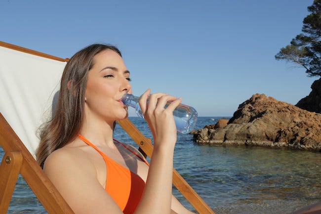beachgoer drinking bottle of water