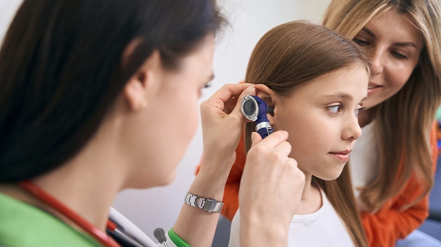 Doctor revisando el oido de una niña pequeña