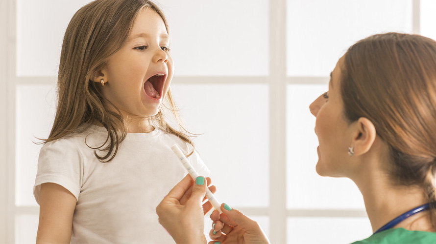 Persona adulta administrando medicamento a niña