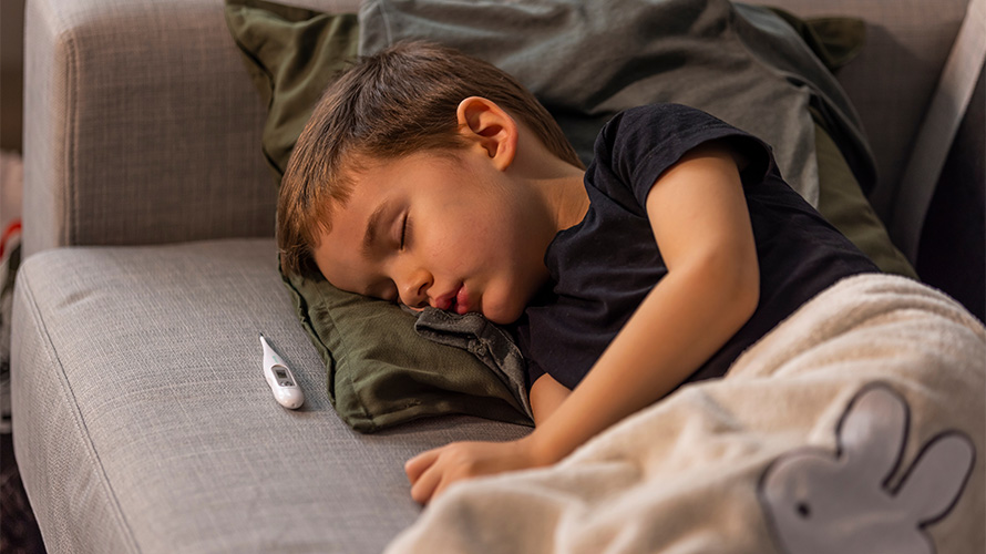 Niño pequeño enfermo recostado en sillon