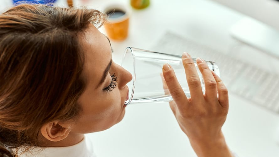 Mujer adulta tomando vaso con agua