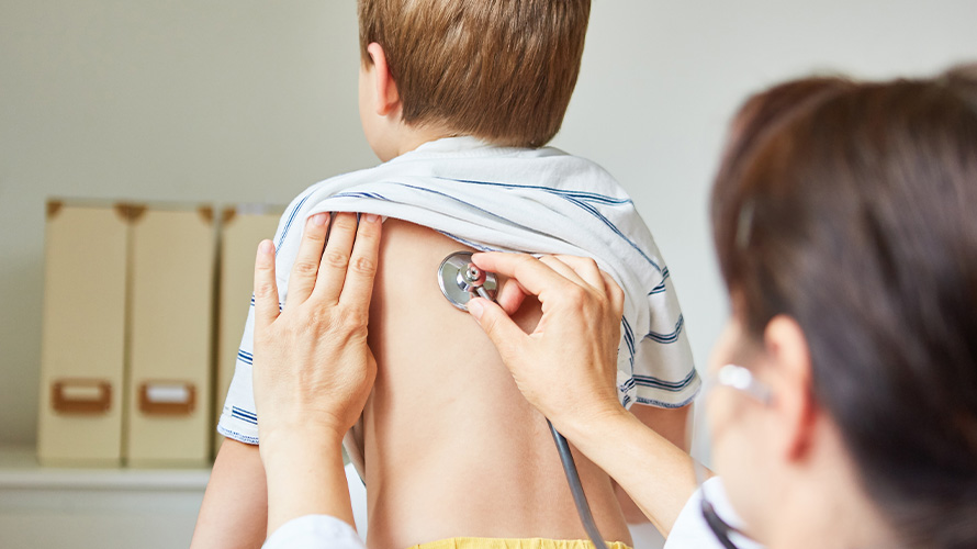Doctor revisando a niño con Bronquitis