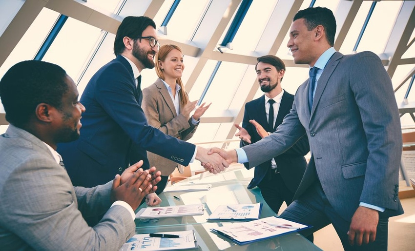 Businesspeople shaking hands at conference room table