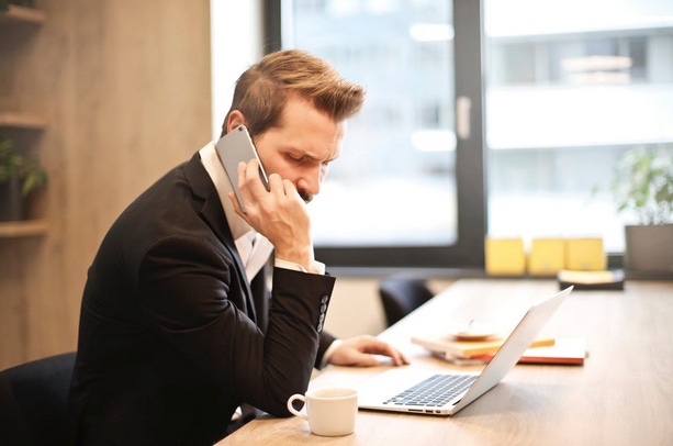 Businessperson on phone with computer and coffee cup
