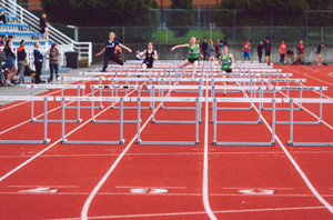 Track with runners jumping hurdles