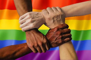 Diverse hands on LGBTQ flag