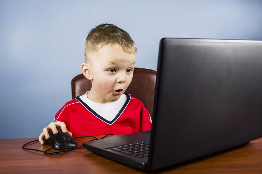 Young boy at desk using laptop