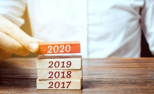 Businessman builds wooden blocks 2020. The concept of the beginning of the new year. New goals. Next decade. Trends and changes in the world. Build