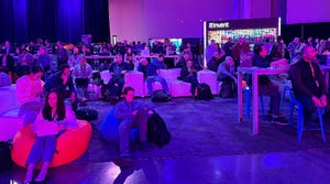 AWS Re:Invent attendees watch Adam Selipsky's keynote on big screen outside conference hall.