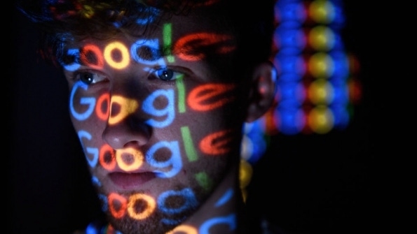 Google logos projected on man's face