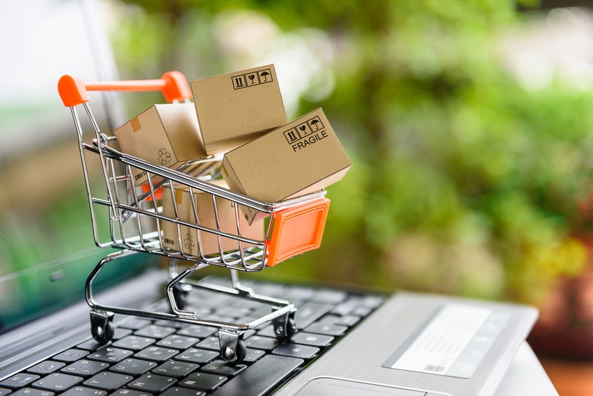 E-commerce symbol of shopping cart over laptop