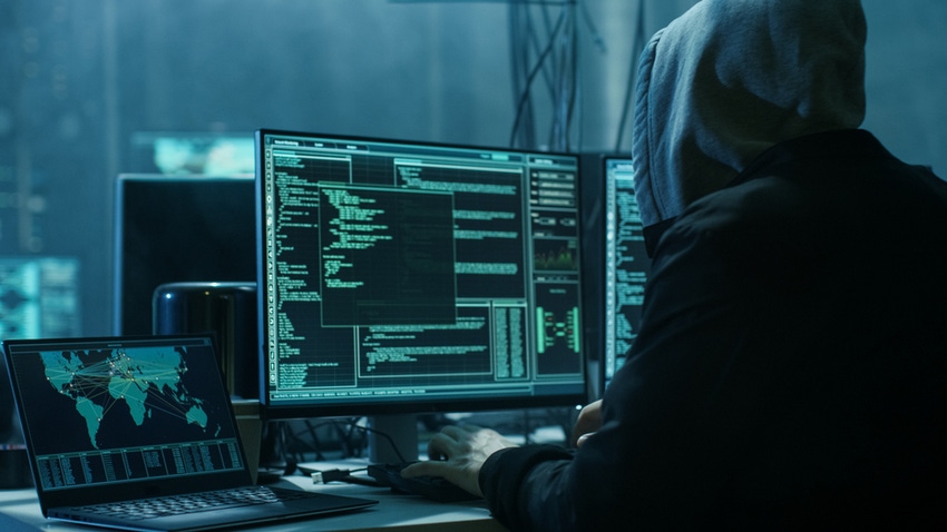 Malicious hacker at computer with code