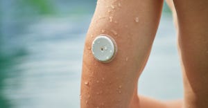 continuous glucose monitor on swimmer's arm