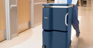 Tablo hemodialysis system being pushed through a hospital hallway by a person wearing scrubs.