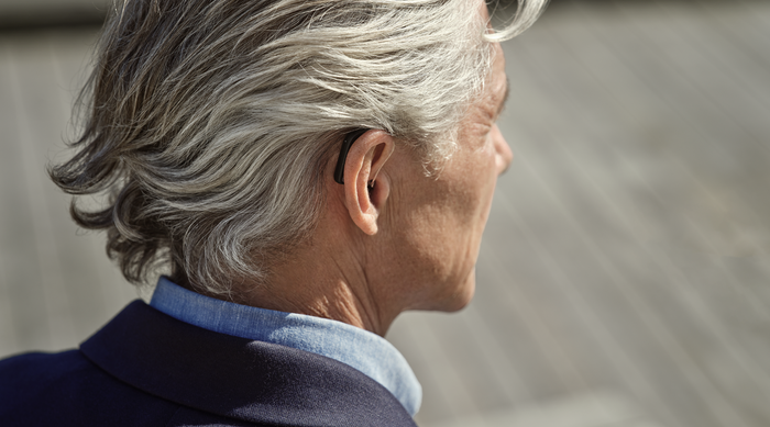 Widex SmartRIC hearing aid worn by a senior man shown from behind