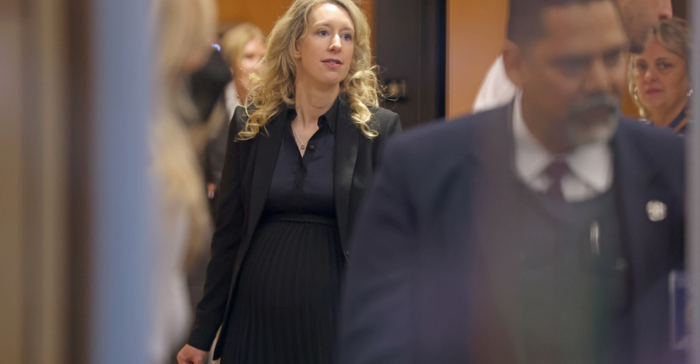 A pregnant Elizabeth Holmes goes through a security checkpoint as she arrives at federal court on November 18, 2022 in San Jose, California. Holmes appeared in federal court for sentencing after being convicted of four counts of fraud.