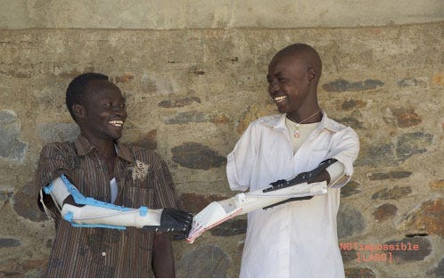 Daniel (r) and Mohammad and their 3-D printed prosthetic arms. (Courtesy Not Impossible Labs)